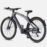 A dark gray electric bicycle with a step-through frame, black tires, and a rear fender, shown from a three-quarters angle on a light gray background.